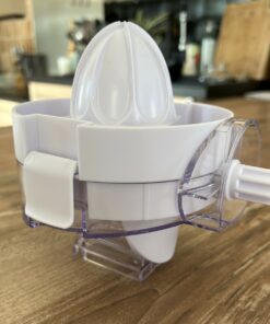 Accessoire presse-agrumes vu de trois-quarts, avec l’axe d’entraînement qui se fixe sur la manivelle du râpeur trancheur